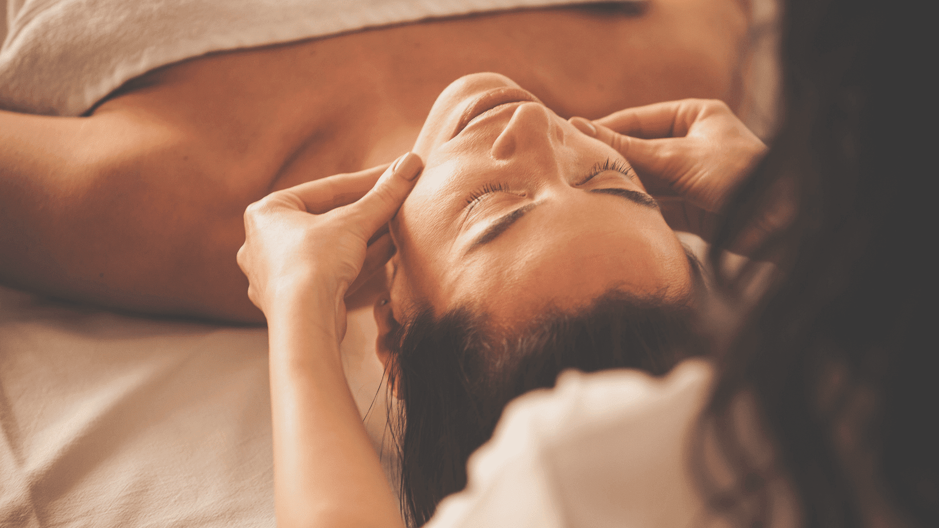 Close-up of a person receiving a facial massage, emphasizing relaxation and well-being.